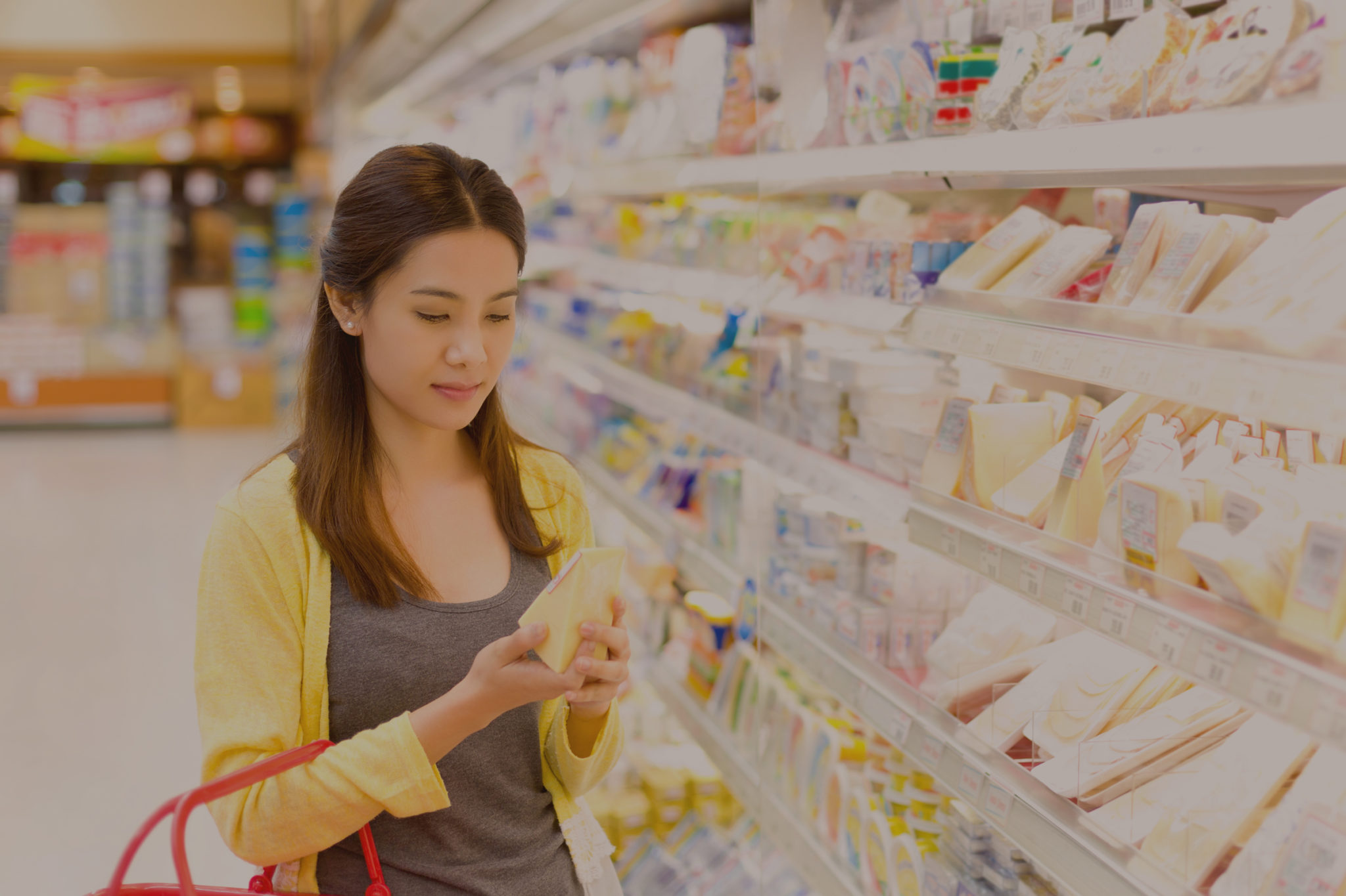 Woman buying cheese in the supermarket.